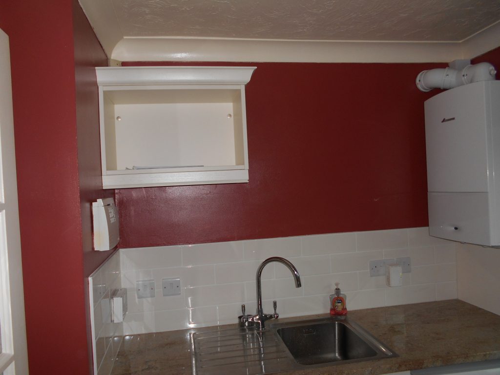 Utility room with reddish paint
